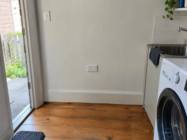 Wall power point above skirting in a kitchen with timber floor and laundry sink in Lewisham